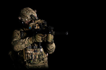 Army soldier in Combat Uniform with assault rifle, combat helmet and night vision device. Studio...
