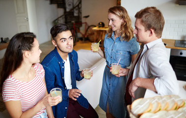 Group of friends with homemade cocktails relaxing at home by talk