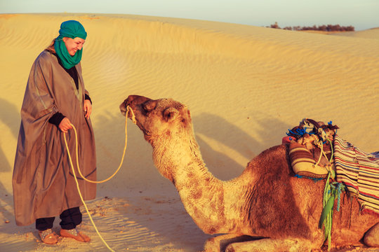 Woman with a camel in the Sahara desert.