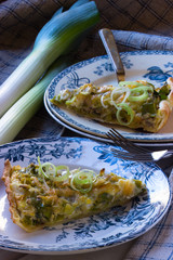 Ein Stück Lauchkuchen vegetarisch auf einem anitken Französischem Teller angerichtet © foodolia