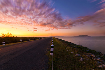 Landscaped walkway around a meadow at sunset sky change from blue to orange,Walkway with stunning views for jogging