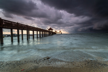 Obraz premium Long exposure Cloudy sunrise shot at jetty. Image contain certain grain or noise and soft focus when view at full resolution