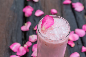 Ice tea with rose milk on wooden table