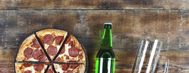 Pizza à la bière et au pepperoni sur une table en bois dans un pub ou une pizzeria