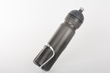Grey bike water bottle inserted to holder, studio photo, isolated on white background.