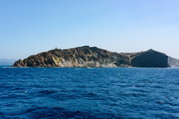 Fototapeta na wymiar Rocky island with church. Santorini islands, Greece in summer.