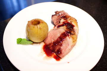 Hot meat with baked apple on the plate