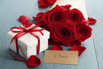 gift box with red roses bouquet for 8 march on blue wood table