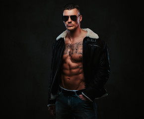 Fototapeta premium A macho stylish man on a dark background.