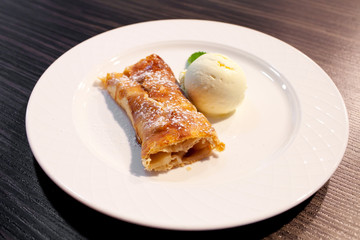 Apple strudel and ice cream on the plate
