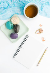 Fototapeta na wymiar Top view flat lay Blank white notebook mockup with macarons and tea cup. Art, writing concept. Text space
