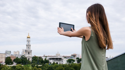 Tourist photography. woman takes pictures of the city sights on her tablet. Traveler lifestyle concept.