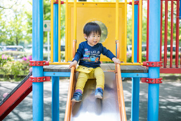 公園の滑り台と笑顔の子供