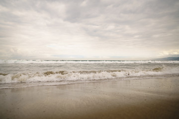 Fototapeta na wymiar ocean waves on Santa Monica beach in cloudy november day