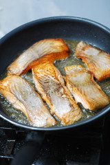  large steak of salmon is fried in sunflower oil.