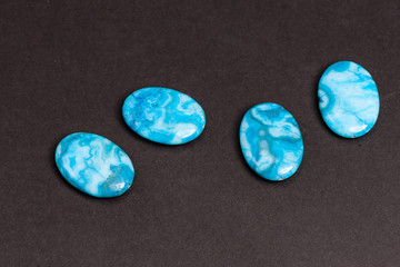 four blue flat buttons used to create jewelry