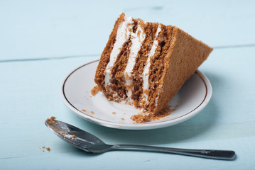 Layered dessert on a white plate and a small spoon,