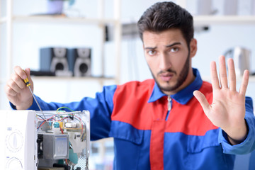 Young repairman fixing and repairing microwave oven