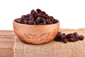 raisins in bowl on wooden table.