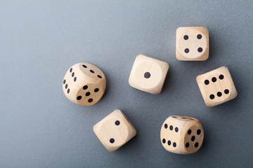 Six wooden dice on gray table top view. Board game. Gambling devices.