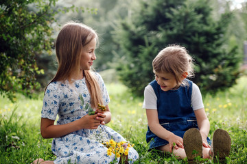 two little sisters in   summer day in   park.