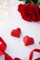 Valentines day background with chocolate hearts and beautiful red rose flower