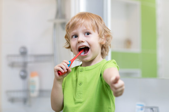 Child boy brushes teeth in bathroom