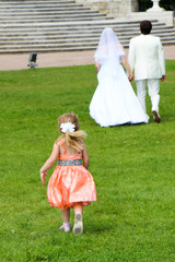 Fototapeta premium A beautiful girl is running after the newlyweds