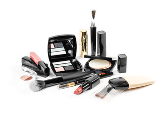 A lot of different cosmetics in one photograph. Lipstick, eye shadow, mascara, mirror, concealer, brushes. On a white background