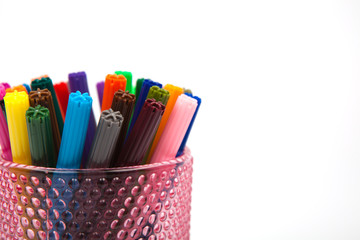 Group of color felt-tipped pens in a glass, white background