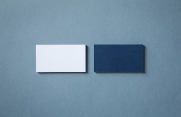 Thick blank double-sided business cards with textured surface stacked up on a grey background
