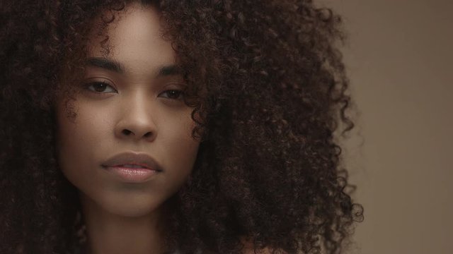 tilt moving camera showing closeup portrait of mixed race black woman in studio shoot