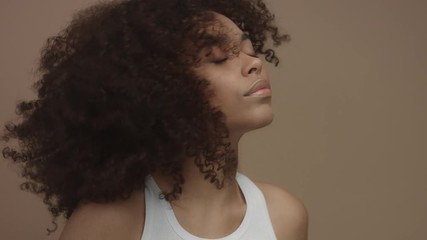 black model with huge curly hair moving shaking hair in slow motion from 60 fps studio shoot - Powered by Adobe
