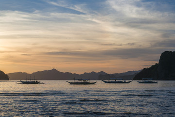 Naklejka na ściany i meble Bangka boats view at beautiful sunset on El Nido bay, Palawan island, Philippines
