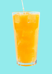 fizzy drink with ice in glass on blue background