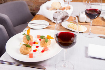 Plum dumplings with cinnamon, white chocolate and vanilla sauce served in a restaurant