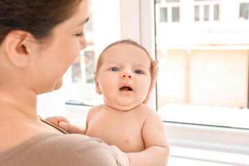 Young mother with cute baby at home