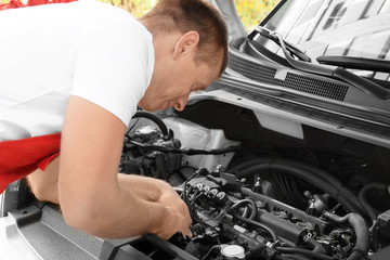 Fototapeta na wymiar Auto mechanic repairing car outdoors
