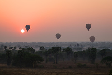 Silhouette of ancient temples and pagodas and several hot-air balloons above the ancient plain of Bagan in Myanmar (Burma) at sunrise. Copy space.