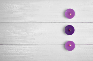 Beautiful burning candles on light wooden background