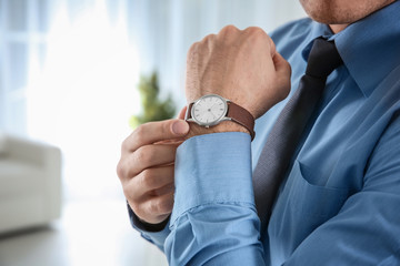 Manager with wrist watch indoors, closeup