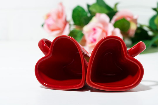 red coffee cups in the form of hearts and roses, closeup