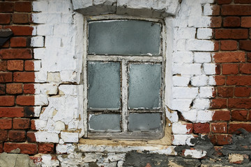 an old window with a rickety wooden frame in the brick wall of a village house