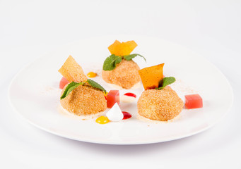 Plum dumplings with cinnamon, white chocolate and vanilla sauce on a white background