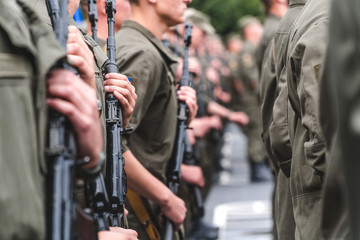 soldiers on construction with weapons in hands hold in hand the automatic machine on the street in...