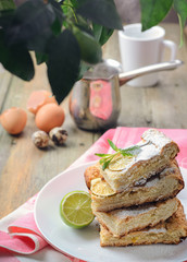 Lemon meringue pie with cup of coffee on white wooden background