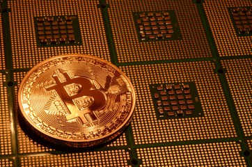 close up of phisical crypto currency bitcoin over computer cpu. background and business concept image.