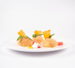 Plum dumplings with cinnamon, white chocolate and vanilla sauce on a white background
