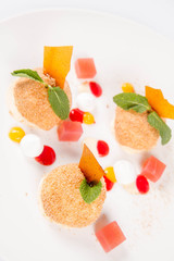 Plum dumplings with cinnamon, white chocolate and vanilla sauce on a white background