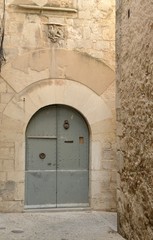 Fototapeta na wymiar Old gate in cobblestone alley in Girona, Spain